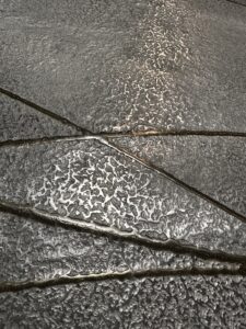 Eine stilvolle Wandfläche zeigt metallische Spachteltechnik mit flüssigem Metall, ideal für kreative Möbelgestaltung. Rezept: Unikat