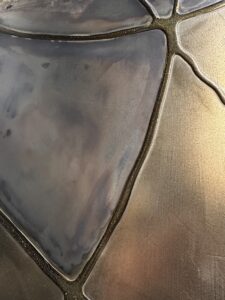 Eine stilvolle Wandfläche zeigt metallische Spachteltechnik mit flüssigem Metall, ideal für kreative Möbelgestaltung. Rezept: Unikat