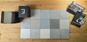 Eine Musterbox mit 14 Grautönen von Einhornwerke zeigt elegante Optionen für kreative Wandgestaltung im Wohnzimmer.