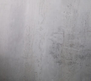 Die Wand zeigt eine natürliche Struktur mit Oberflaeche-STUCCORINO Alt-Berlin in dezenten Grautönen für kreative Wandgestaltung.
