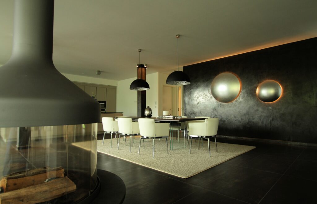 Ein modernes Wohnzimmer zeigt eine stilvolle Wandgestaltung mit STUCCORINO Classic und eleganten Lichteffekten.