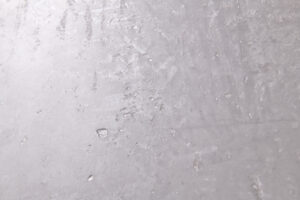 Die Nahaufnahme zeigt eine silberne Wandgestaltung mit Oberflaeche-STUCCORINO, ideal für kreative Wandgestaltungen im Wohnzimmer.