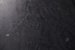 Die Oberfläche zeigt eine dunkle, strukturierte Wandgestaltung mit rauer Textur, ideal für kreative Wohnzimmerwände.