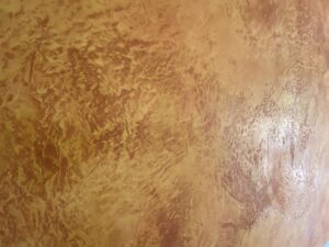 Diese Wand zeigt eine kunstvolle Wandgestaltung mit der Oberflaeche STUCCORINO Effect auf warmem Kalkputz.
