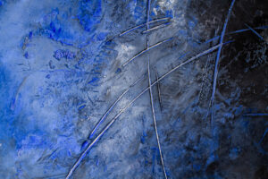 Abstrakte Wandgestaltung mit blauen und silbernen Pigmenten, die den Oberflächen-StuccoRino-Effect kunstvoll hervorheben.