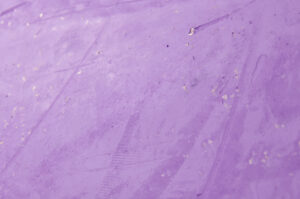 Die Wand zeigt eine glatte, violette Oberfläche mit einem Hauch von Goldglimmer, ideal für kreative Wandgestaltung.