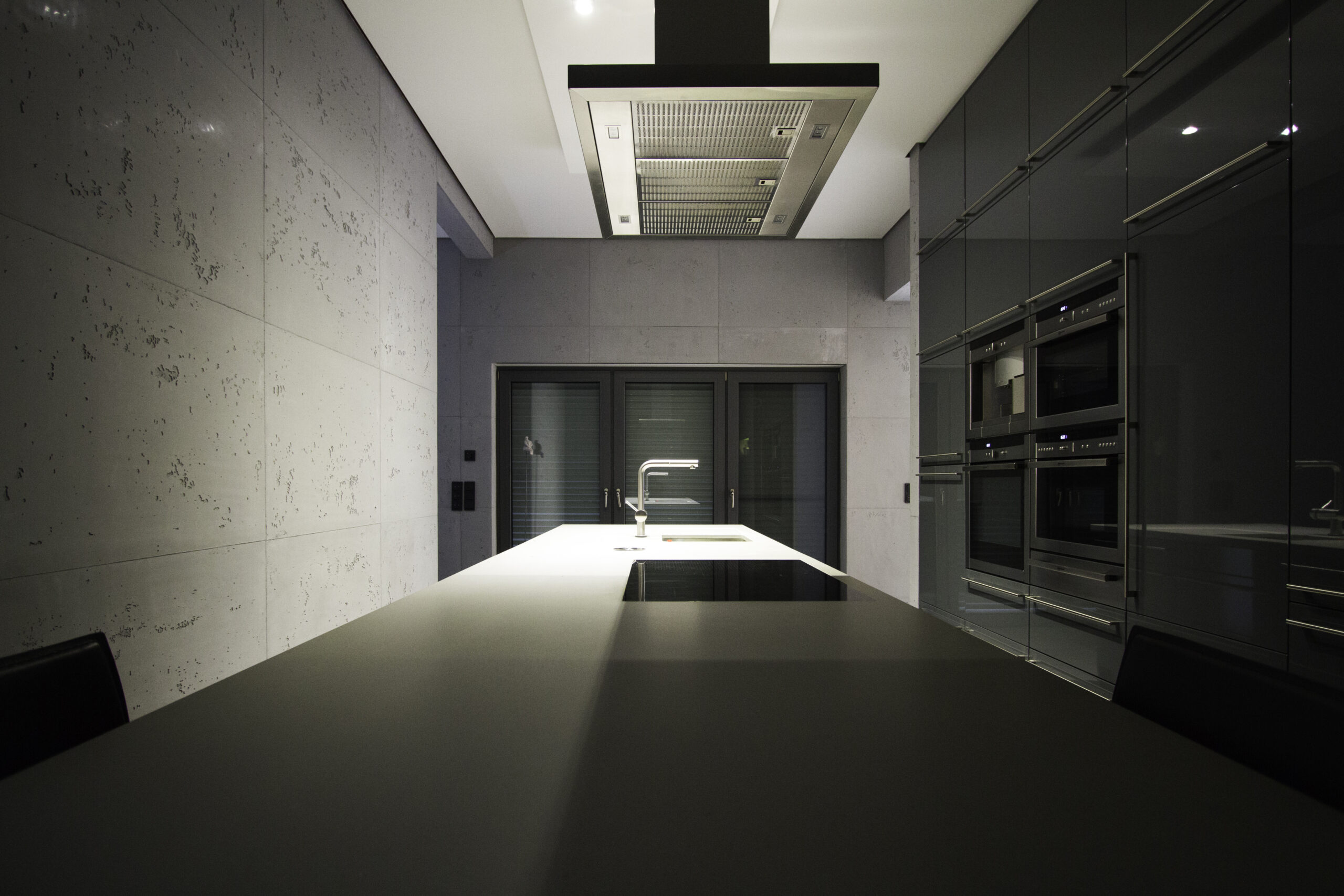 Ein modernes Wohnzimmer zeigt elegante Wandgestaltung in Betonoptik und stilvollem Interieur.