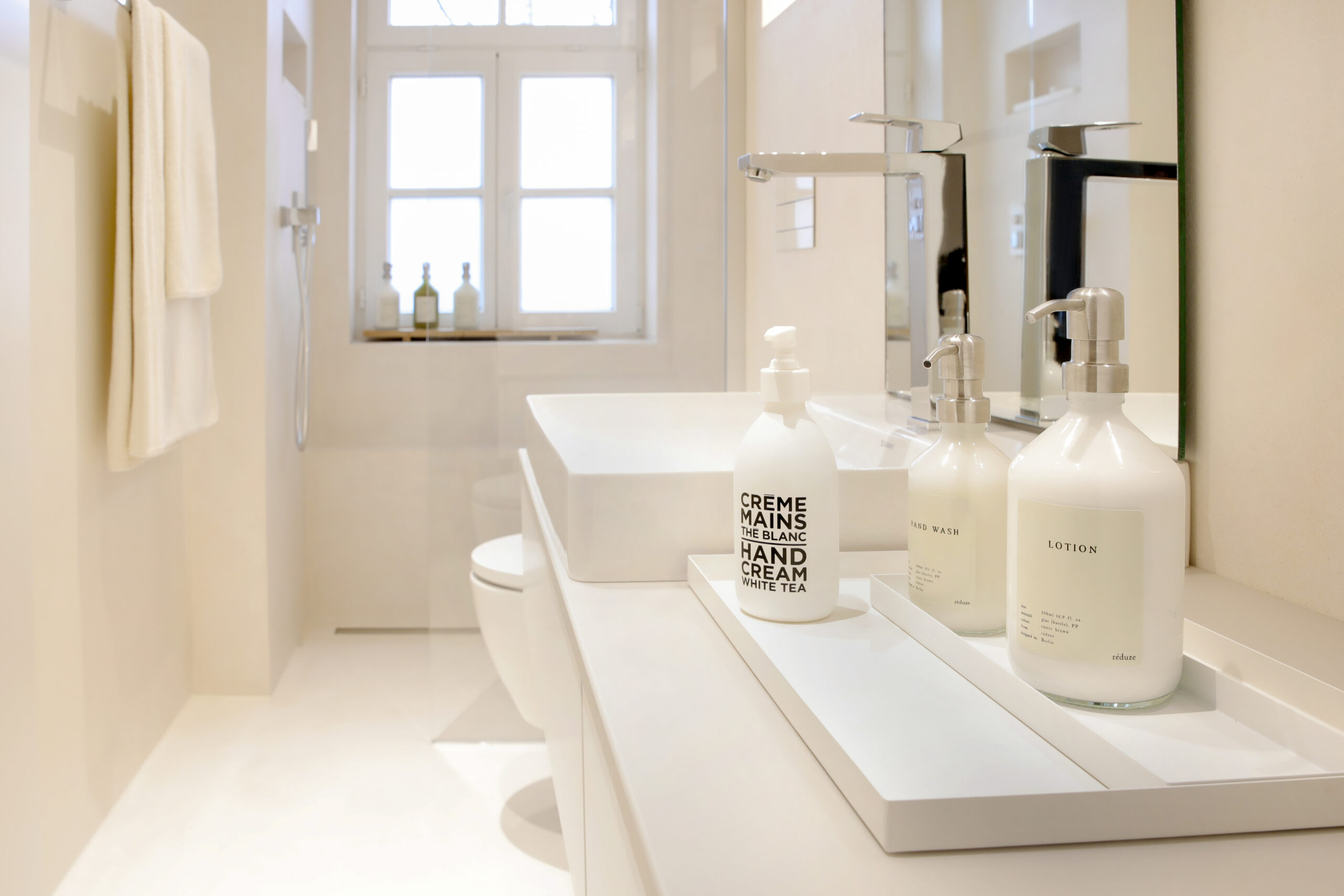 Ein modernes, fugenloses Badezimmer mit stilvoller Wandgestaltung und eleganten Accessoires aus der Einhornwerke-Kollektion.