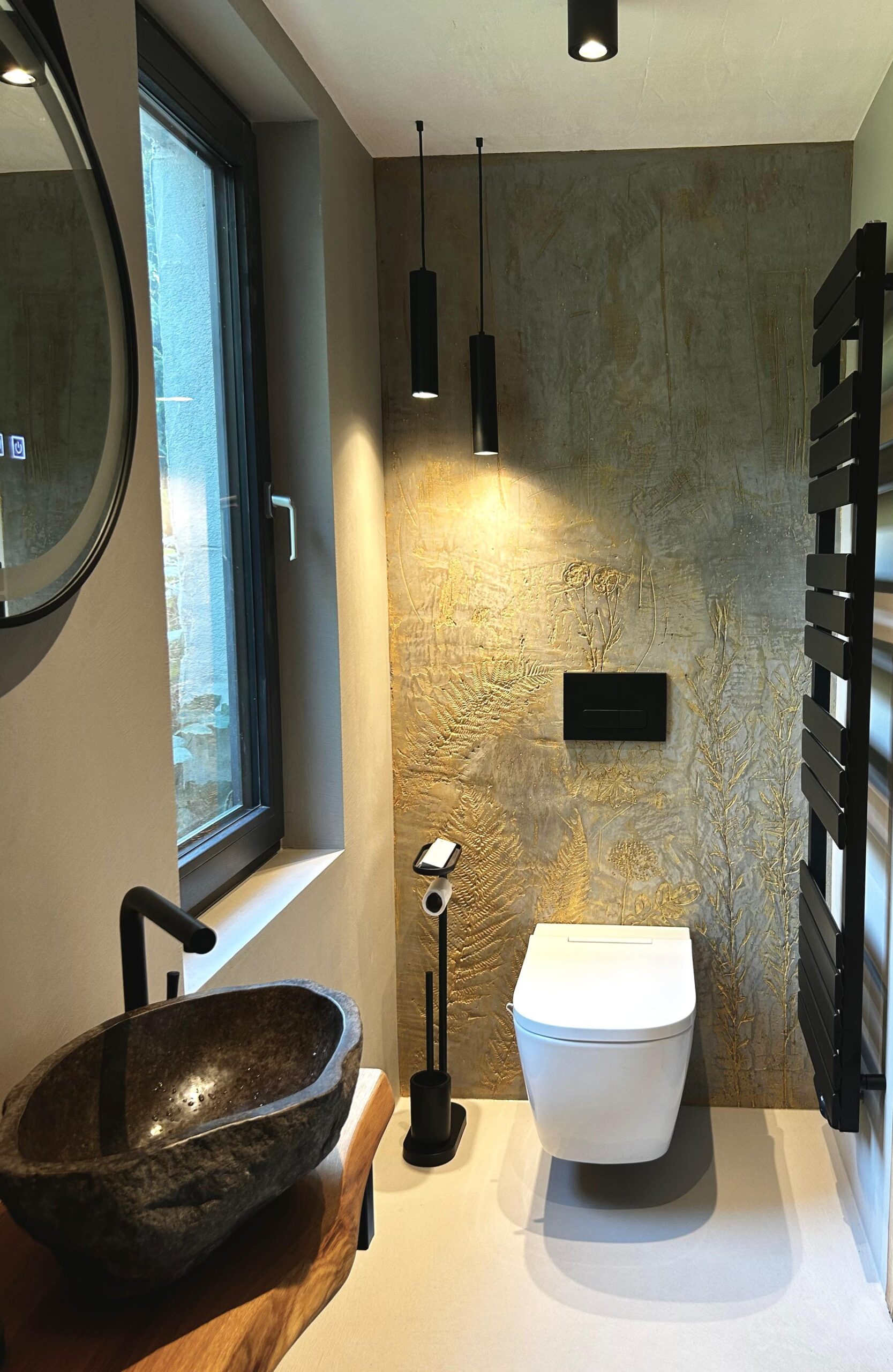 Ein modernes Badezimmer mit stilvoller Wandgestaltung und einem einzigartigen Waschbecken aus Naturstein.