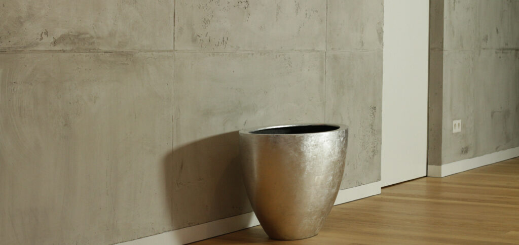 Ein stilvolles Wohnzimmer zeigt eine moderne Wandgestaltung mit Oberflaeche-STUCCORINO-®-Torino-Beton von Einhornwerke.