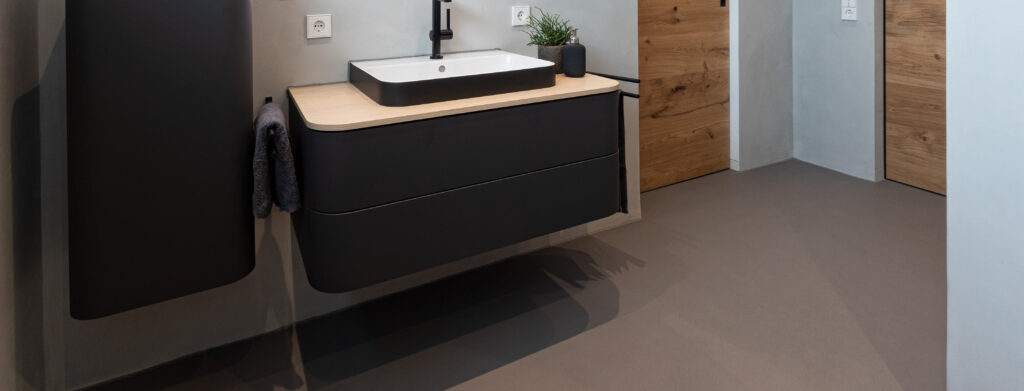 Modernes Badezimmer mit fugenlosem Boden und stilvoller Wandgestaltung von Einhornwerke als Alternative zu Fliesen.