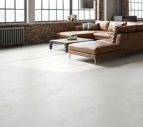 Ein modernes Wohnzimmer mit stilvollem Designlboden-HERKULES-2704-2-2 und eleganter Wandgestaltung in Betonoptik.